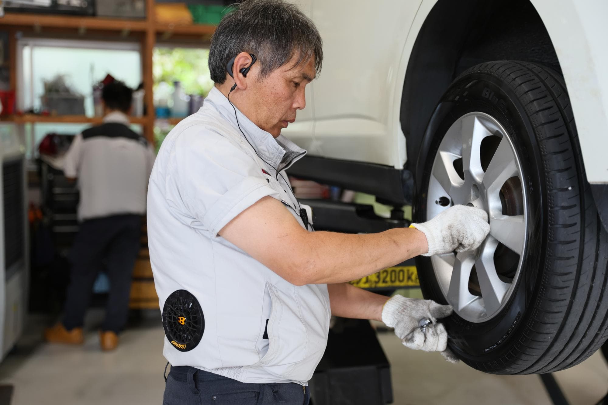 修理工場での車のタイヤ整備している整備士