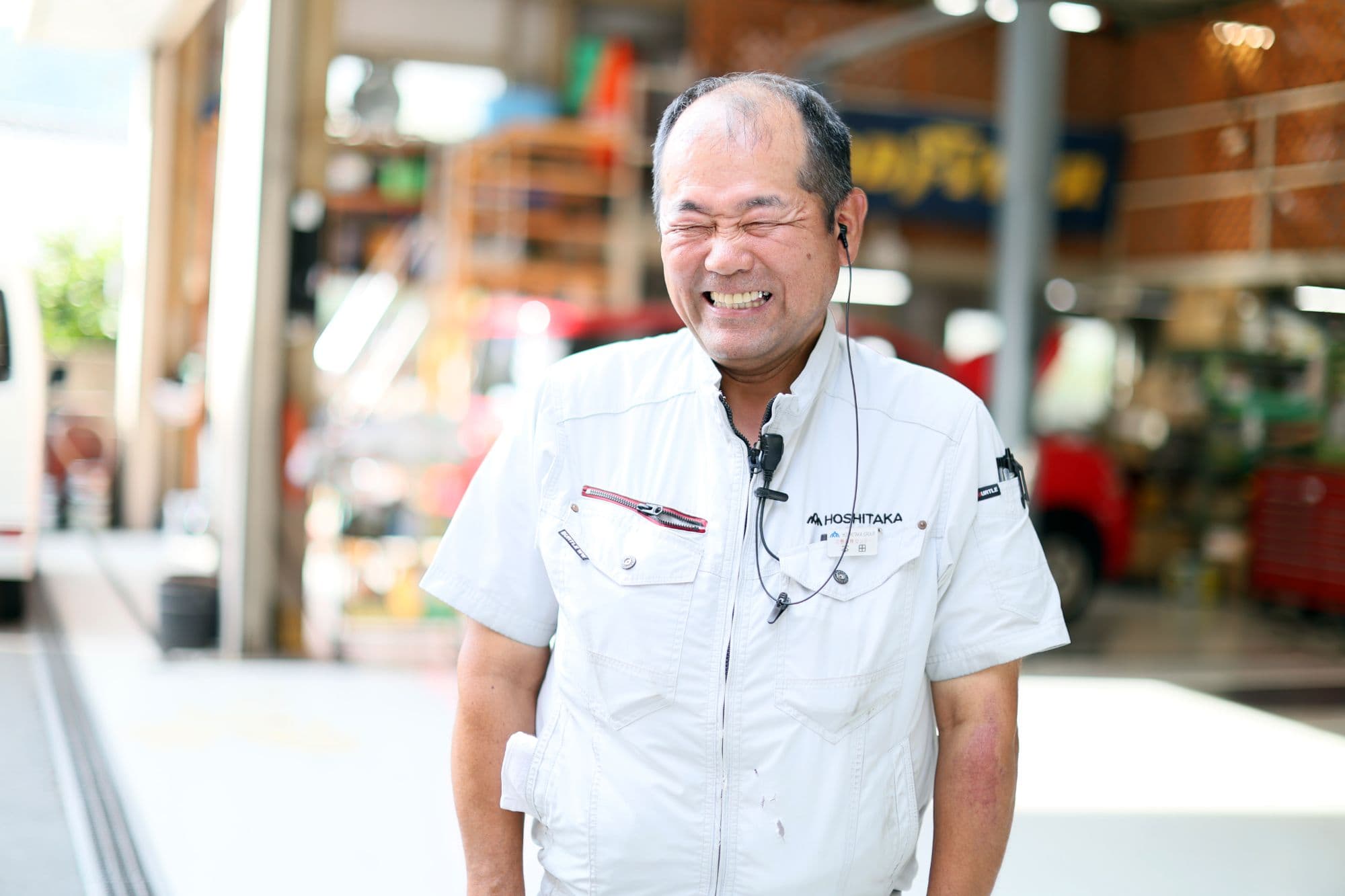 ヘッドセットをつけた明るい表情の工場作業員