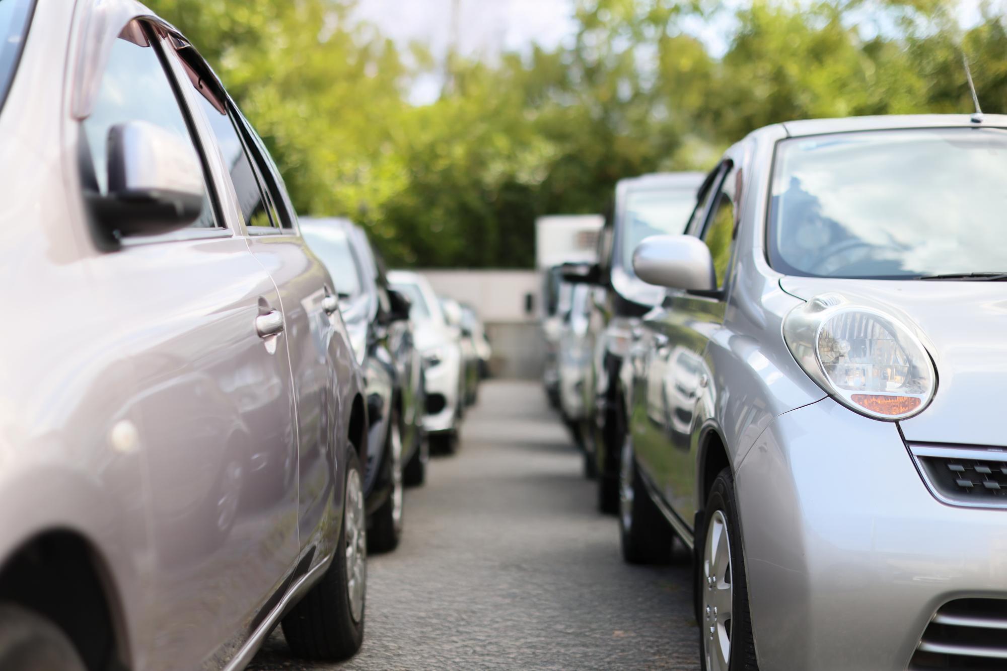 駐車場に整列駐車する複数台の乗用車