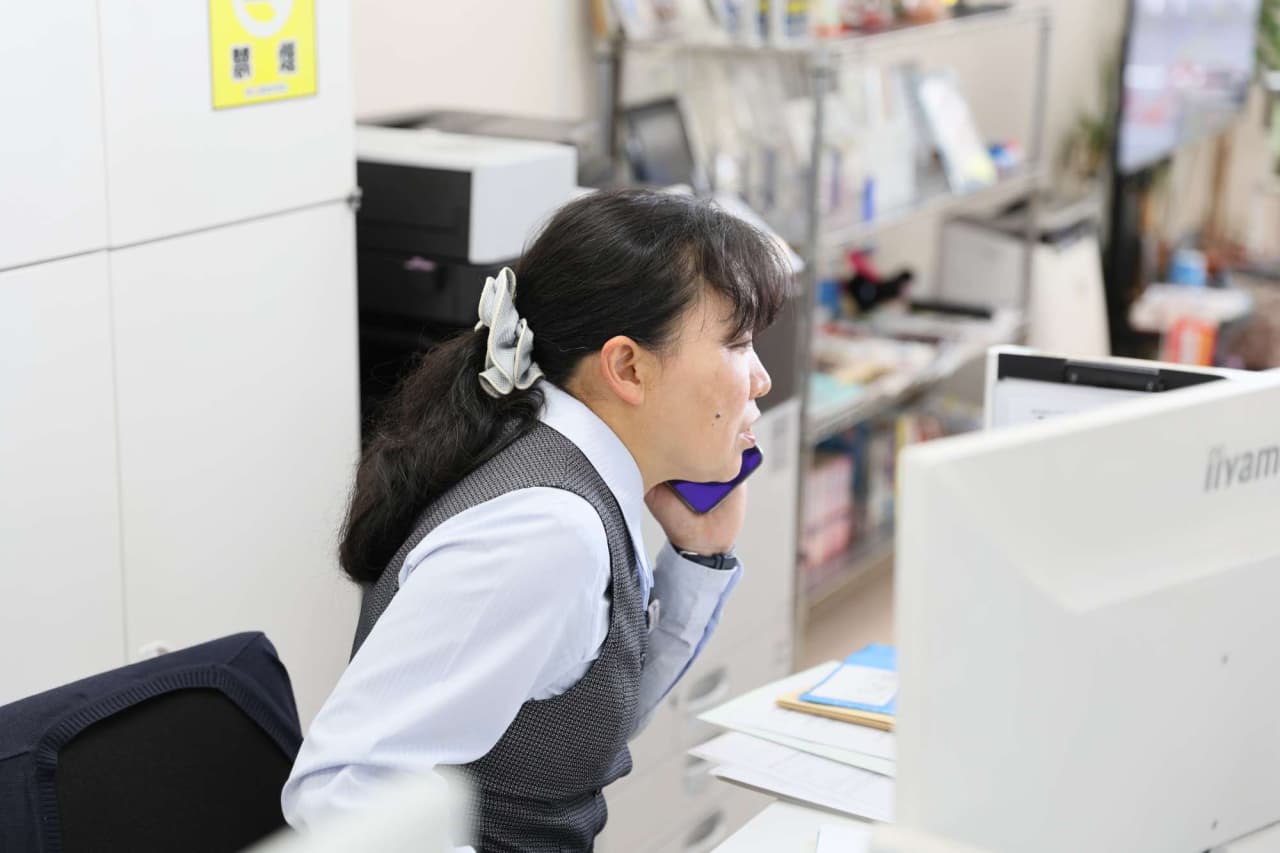 ヘッドセットを着用してオフィスで電話対応する女性スタッフ