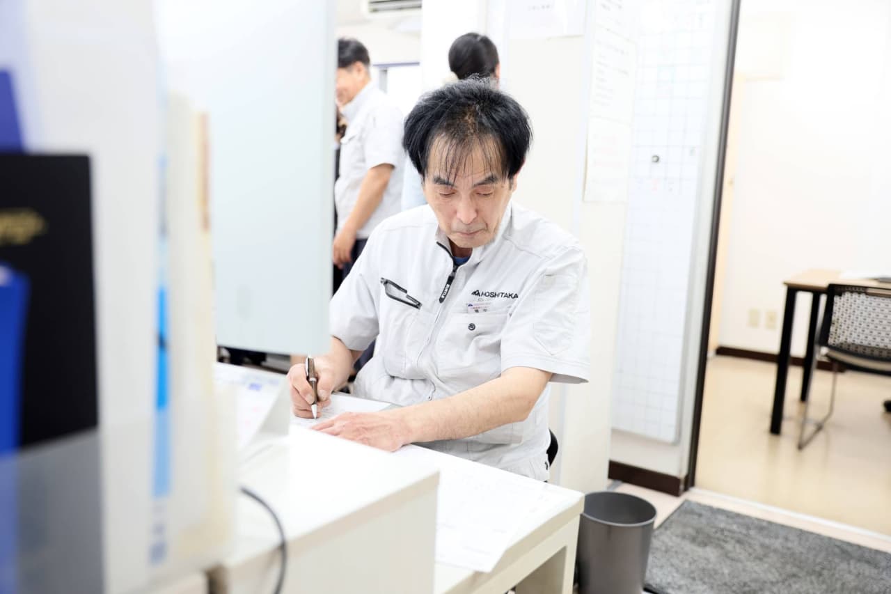 男性技術者が書類に記入している様子